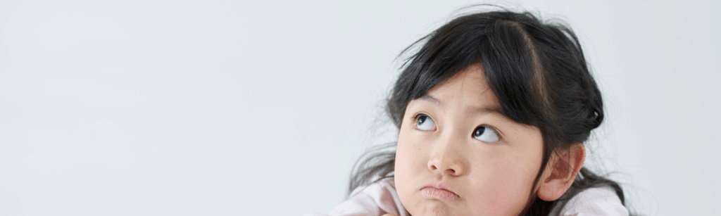 a young girl looks thoughtfully up and to her right.